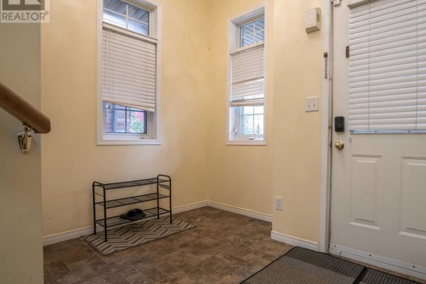 Entryway with cream-colored walls, two small windows with blinds, shoe rack, and white front door. - 971 Creekside Drive, Waterloo