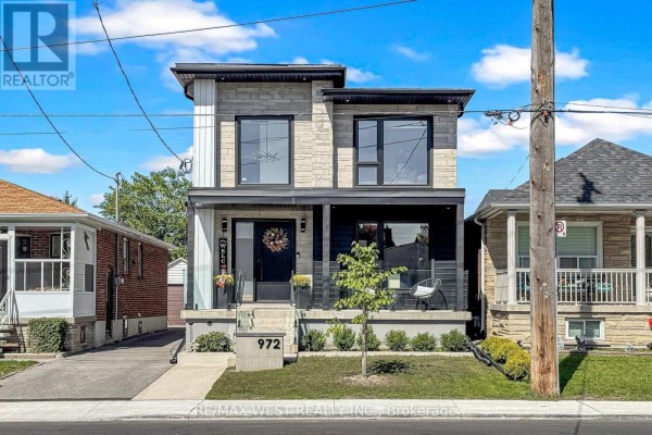 Front view of the house with a paved driveway, grass lawn, and stone accents. - 972 Castlefield Avenue, Toronto