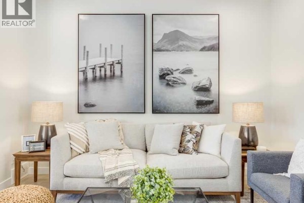 Living room featuring a light gray sofa, two lamps, and framed art - 975 Edgefield Avenue, Strathmore