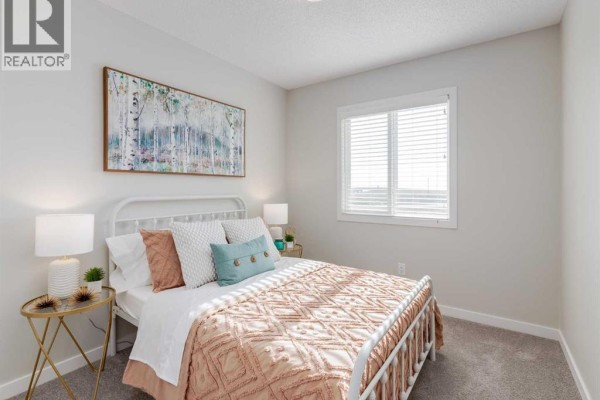 Cozy bedroom with a double bed, decorative pillows, and a window - 975 Edgefield Avenue, Strathmore