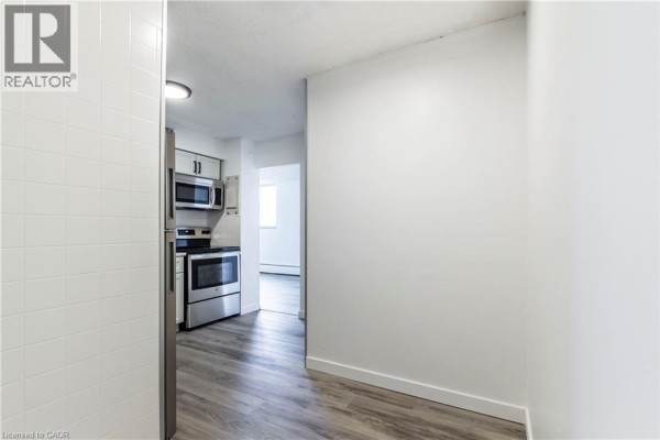 View from the kitchen towards the hallway, showcasing light-colored walls and flooring. - 975 Warwick Court Unit# 908, Burlington