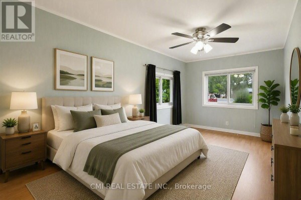 Bedroom with king-sized bed, ceiling fan, and large windows - 977 County Rd 38 Trent Hills