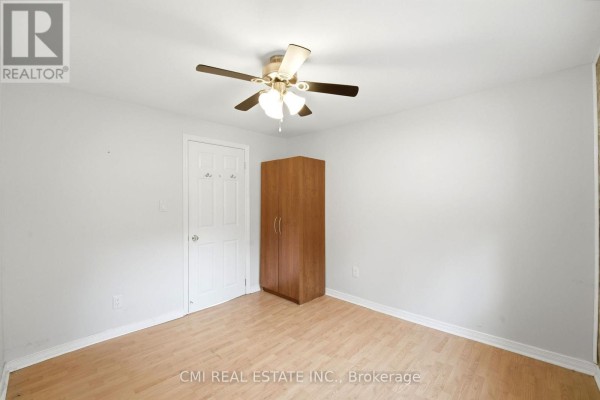 Bedroom with ceiling fan, wooden wardrobe, and laminate flooring - 977 County Rd 38 Trent Hills