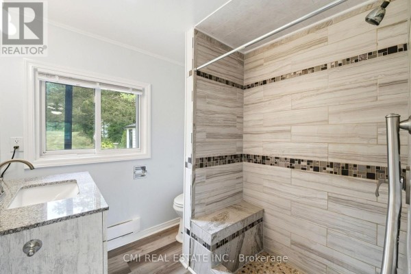 Renovated bathroom with walk-in shower, built-in bench, granite vanity, and window - 977 County Rd 38 Trent Hills