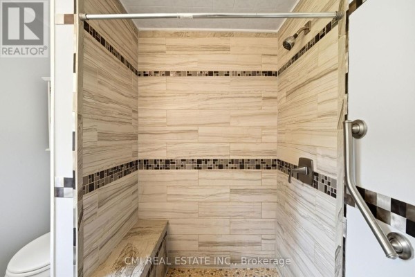 Tiled walk-in shower with bench, pebble floor, and grab bar - 977 County Rd 38 Trent Hills