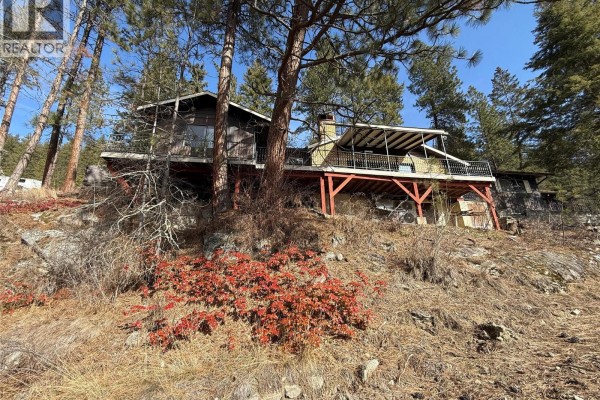 Two-story house on a slope with decks and wooden exterior. - 9779 3a Highway, Kuskanook