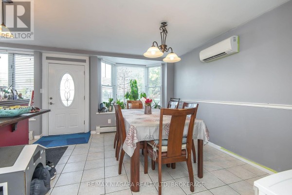 Modern kitchen with white cabinets, stainless steel appliances, and a central island - 98 Chippawa Road, Port Colborne