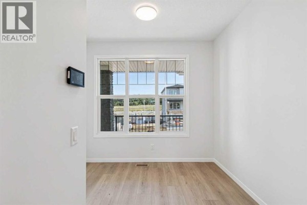 View from a room through a large window showing the house exterior and neighboring properties. - 98 Creekview Avenue Sw, Calgary