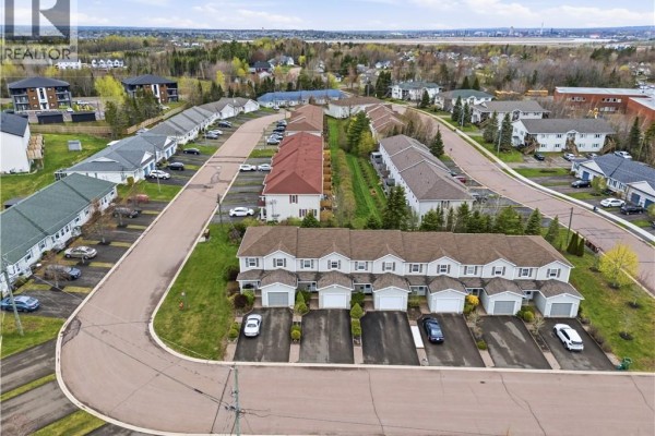 Aerial view of a townhouse complex with curved streets and surrounding residential buildings. - 98 Firmin Crescent, Dieppe