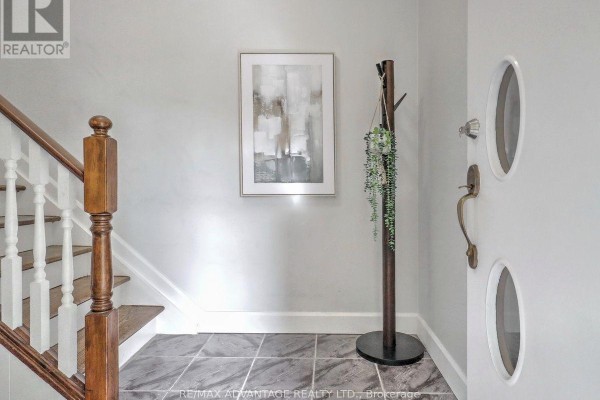 Interior entryway with a staircase, modern art, and a floor lamp. - 98 Goldwick Crescent, London East