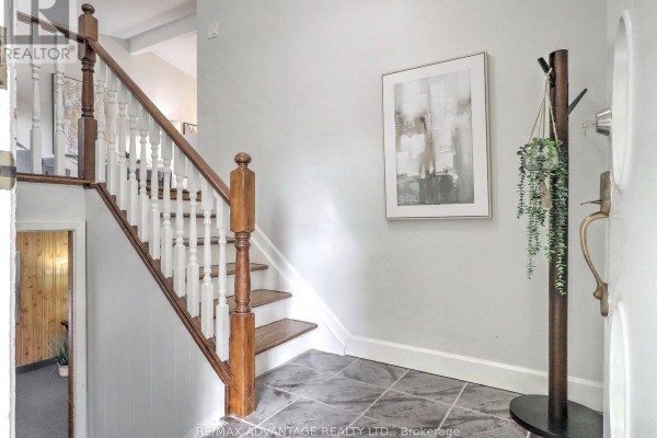 View of the foyer and staircase with wooden banisters and grey walls. - 98 Goldwick Crescent, London East
