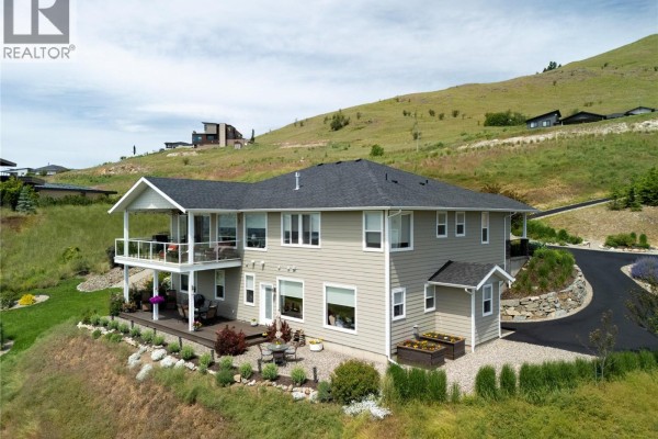 Exterior view of the house with a balcony, landscaped garden, and driveway. - 98 Ranchland Place, Coldstream