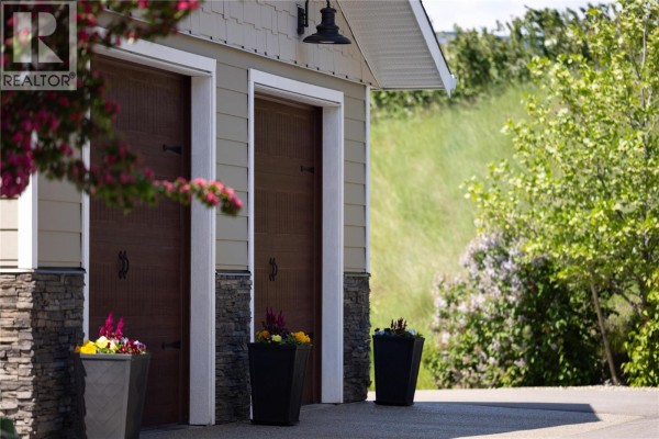 Detail of the garage doors with planters and stone accents. - 98 Ranchland Place, Coldstream