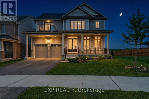 Front view of a light gray siding house with a covered porch and two-car garage. - 98 Rea Drive, Centre Wellington