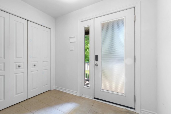 Interior entryway with beige tiled floor, white walls, and a frosted glass door. - 98 Rue De La Galère, Gatineau