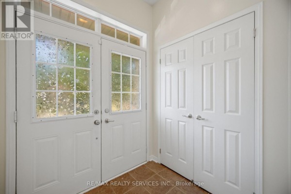 Interior foyer with white double doors featuring frosted glass and a double closet. - 98 Teal Crest Circle, Brampton