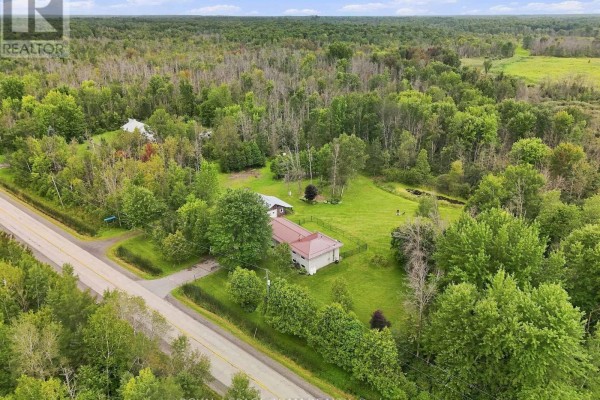 Aerial view showing the residential property adjacent to a paved road and dense woodland. - 980 County Rd 44, North Grenville