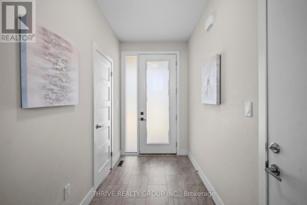 Interior hallway with light walls, tiled floor, and white doors leading to rooms. - 981 West Village Square, London North