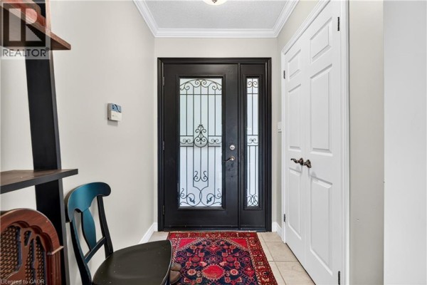 Entrance hallway with a black front door, decorative glass, and beige walls. - 984 #8 Highway, Stoney Creek