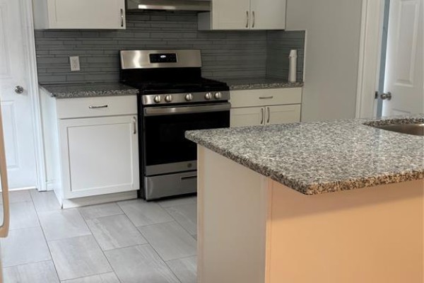 Rear view of a small building with a dark door and a stamped concrete patio. - 984 Ellrose, Windsor