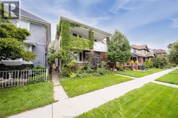 View of the duplex from the side, showing the brick exterior and landscaping. - 984 Windermere Road, Windsor