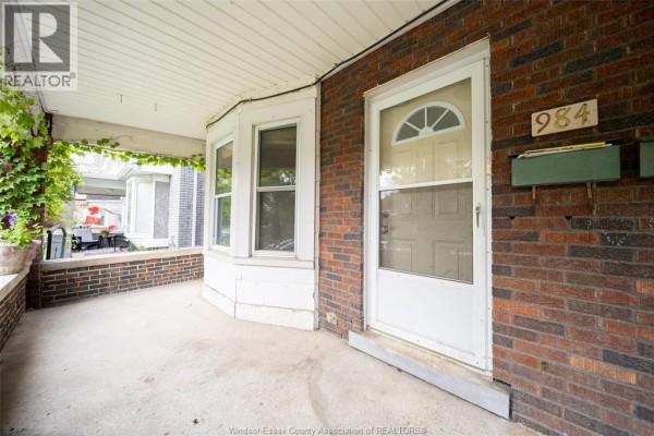 Entrance to the duplex with a white door, brick exterior, and bay windows. - 984 Windermere Road, Windsor