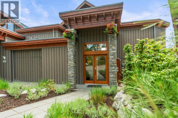 Panoramic view of a large blue lake surrounded by mountains and pine trees. - 9845 Eastside Road Unit# 158, Vernon