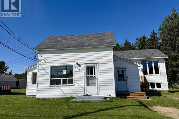 Exterior view of a white house with two separate entrances and a sunny front yard. - 985 Rue Louis G. Daigle, Tracadie