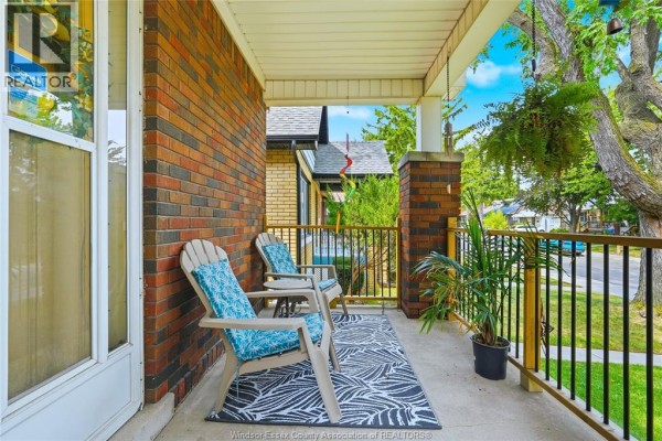 Two Adirondack chairs with blue cushions on a covered porch with a black and white rug. - 987 Curry, Windsor