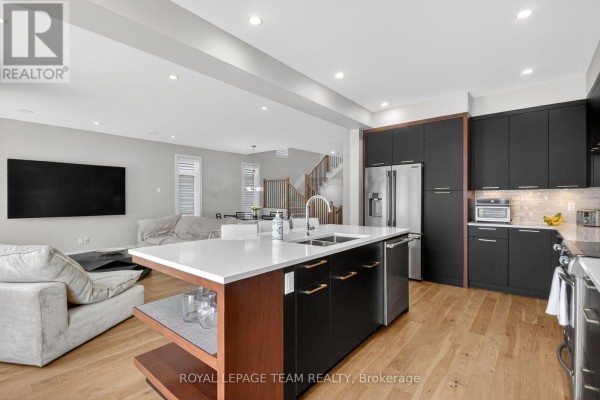Open concept living area with modern kitchen island, seating area, and dining space. - 988 Beckton Heights, Ottawa