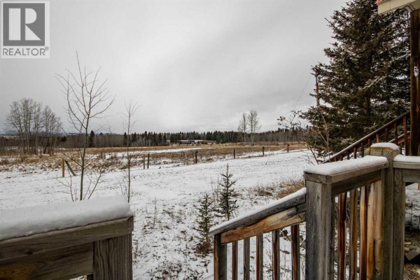 Wide view of a cloudy sky with the sun partially visible over a snow-covered field and distant trees. - 99, 5227 Township Road 320, Rural Mountain View County