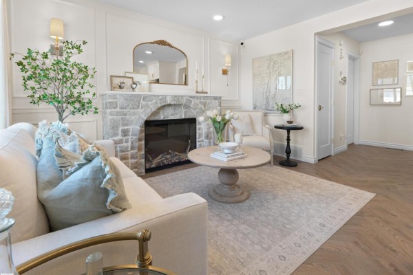 Living room with a white sofa, coffee table, and kitchen in the background. - #99 150 Cashman Cr Sw, Edmonton