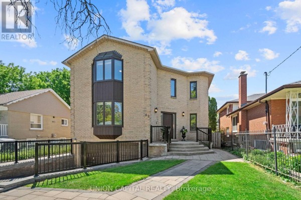 Front porch entrance with concrete steps, black metal railings, and urn planters. - 99 Abitibi Avenue, Toronto