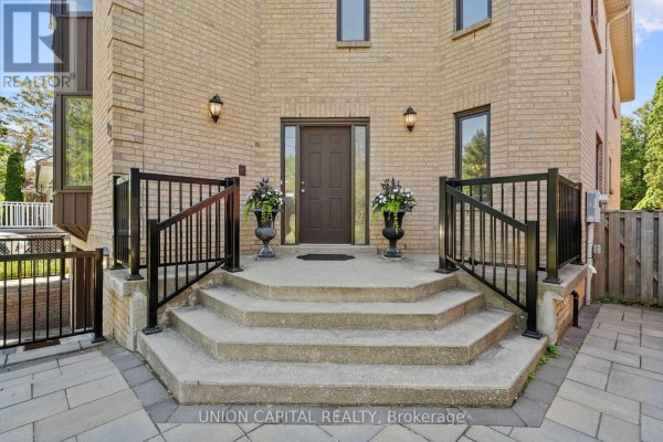 Foyer with tiled floor, white doors, mirrored console table, and artwork. - 99 Abitibi Avenue, Toronto