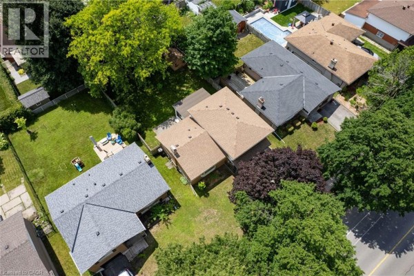 Aerial view of the house and surrounding neighborhood, highlighting the backyard and a swimming pool. - 99 Lorraine Avenue, Kitchener