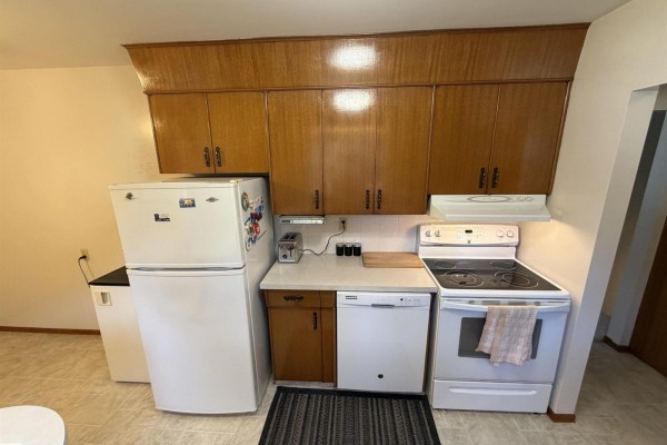 Kitchen with white refrigerator, dishwasher, stove, and wood cabinets. - 99 Pine St, Sherwood Park