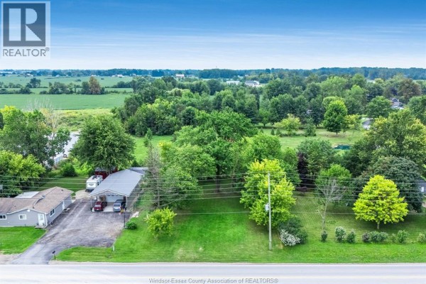 Aerial drone shot showing a property lot outlined in black, adjacent to a building and rural landscape. - 99 Road 4 East, Kingsville