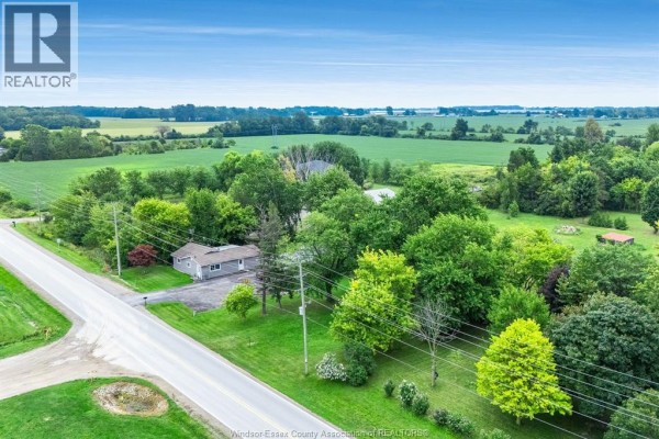 High-angle view of a paved road winding through a green landscape with scattered houses and trees. - 99 Road 4 East, Kingsville