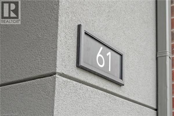 Close-up of the grey building exterior showing unit number 61 on a dark frame. - 99 Roger Street Unit# 61, Waterloo