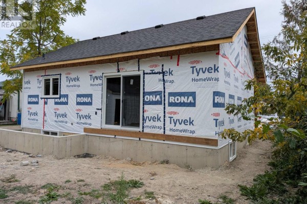 Rear view of the house under construction with a sliding glass door. - 99 St Patrick Street, Kawartha Lakes