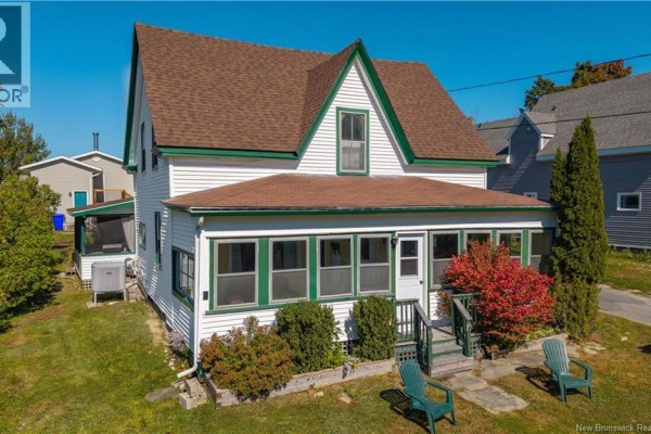 Front exterior of a white house with green trim, a screened-in porch, and a small red bush. - 99 Union Street, St  Stephen