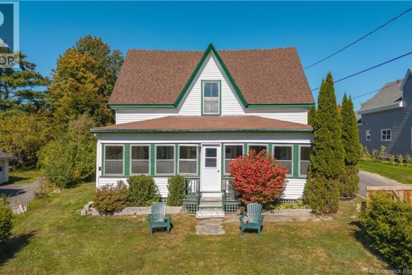 Front facade of a white house with green trim, a gable roof, and two green Adirondack chairs on the lawn. - 99 Union Street, St  Stephen