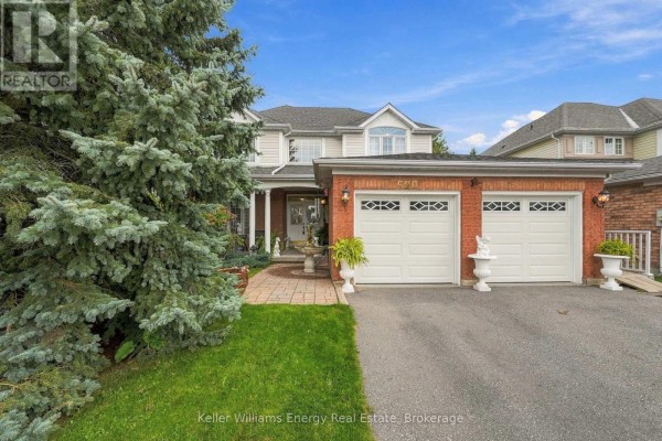 Aerial view of a backyard featuring an oval swimming pool, deck, and surrounding trees. - 990 Glenbourne Drive, Oshawa