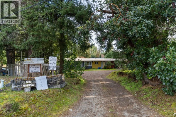 Backyard area with grass, seating, and a canopy structure. - 992 Allenby Rd, Errington