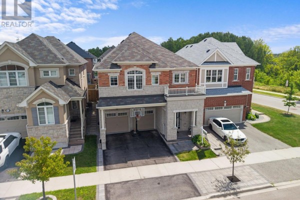 Aerial view of a suburban house with a dark shingle roof, brick and stone exterior, and a two-car garage. - 993 Dragonfly Avenue, Pickering