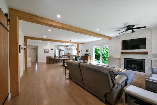 A home office with a white desk, computer, storage shelves, and a large window overlooking a garden. - 9933 Watt Street, Mission