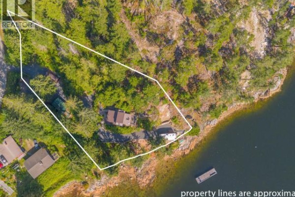 Aerial view of a property outlined with white lines, situated on a rocky, forested shoreline with water views. - 9951 Finn Bay Rd, Powell River