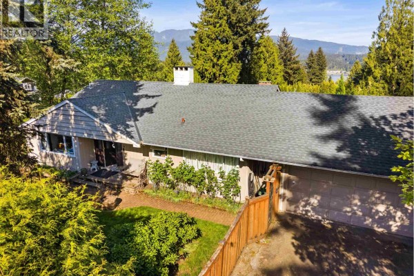 Aerial view of the backyard of a residence with a large wooden deck and green lawn. - 998 Fairway Drive, North Vancouver
