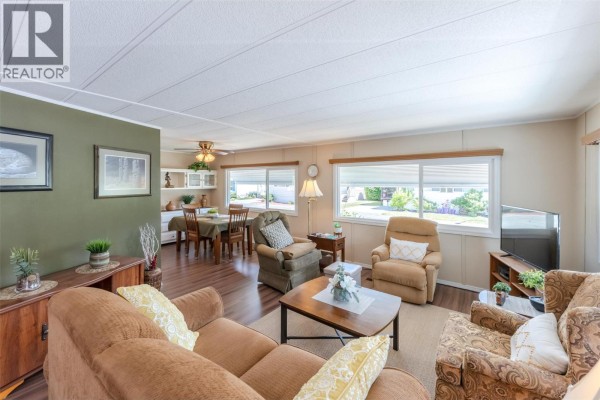Living and dining area with furniture, dining table, and built-in cabinets. - 999 Burnaby Avenue Unit# 66, Penticton