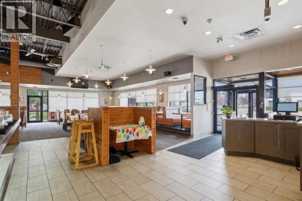 Restaurant dining area with booths, tables, and windows looking out to the street. - 9995 178 Street Nw, Edmonton